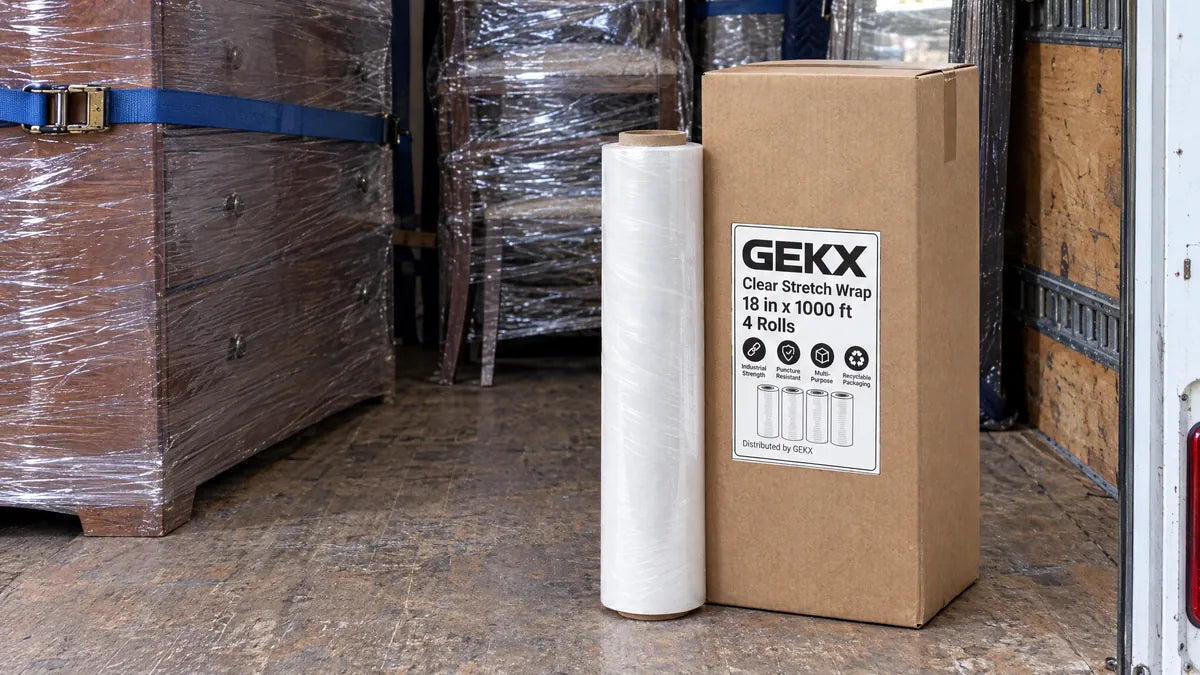 GEKX box and a roll of clear stretch wrap on the floor of a truck loaded with wrapped, strapped furniture